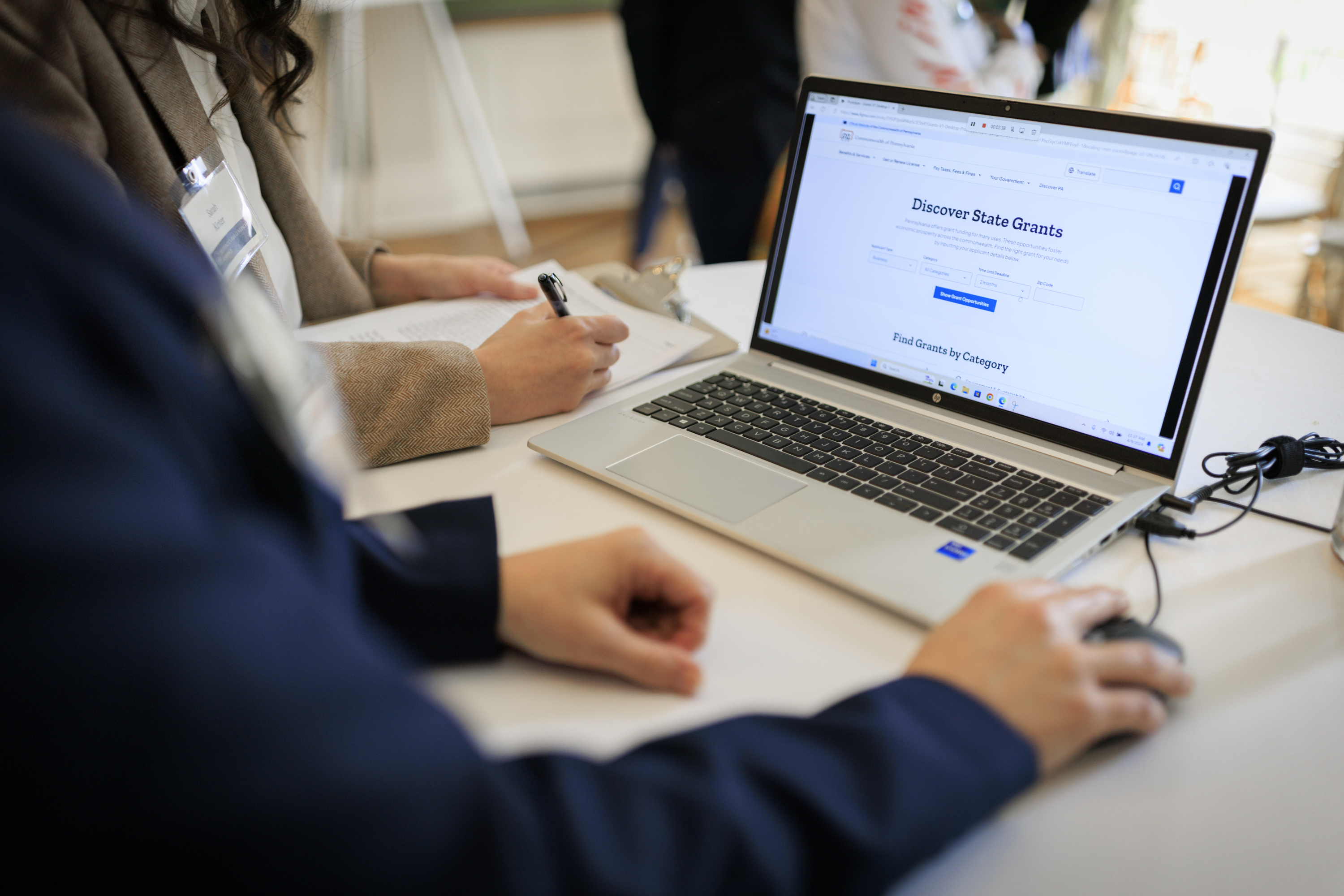 A person uses a laptop computer and mouse to explore the grants tool during a user testing session. 